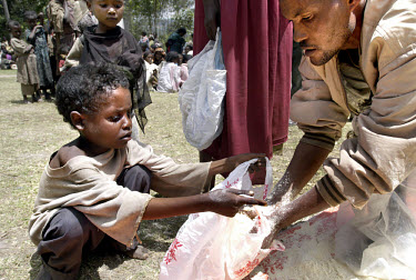 An employee of a local NGO distributes food to children. The severe drought in the south of the country has compounded problems caused by insufficient foreign aid. Around 13 million Ethiopians depend...