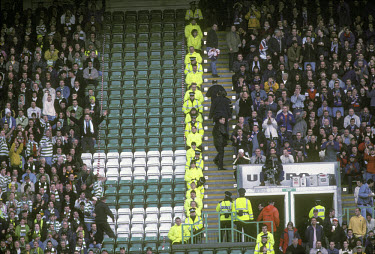 A line of police and stewards separate Celtic and Rangers supporters.The 'Old Firm' rivalry between Celtic and Rangers is renowned as the world's most intense football derby.