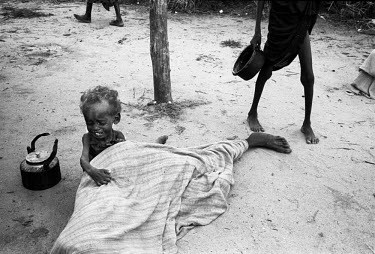 A child cries over its dead mother during the 1992 famine caused by the civil war in Somalia. In 1991 President Barre was overthrown by opposing clans, but they failed to agree on a replacement and p...