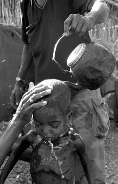 A mother washes her child at a feeding centre during the 1992 famine caused by the civil war in Somalia. In 1991 President Barre was overthrown by opposing clans, but they failed to agree on a replace...