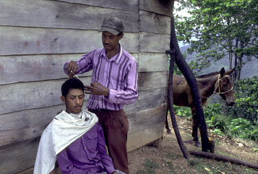 Barber cutting hair in the mountain village of Montesita.