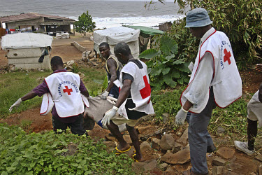 Liberian red cross workers collect the body of a young boy killed by  a stray mortar. Downtown Monrovia is heavily populated and also home to tens of thousands of displaced people. All are vunerable t...