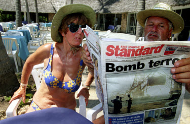The day after the terrorist attacks in Mombasa, tourists read newspaper reports on the terrace of a nearby holiday resort. 13 people were killed when a car bomb exploded outside the Israeli-owned Para...