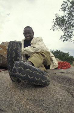 Maasai boy wearing sandals made out of car tyres, on the edge of Serengeti national park.