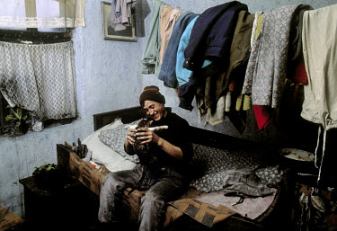 Man playing with his cat in his home in the industrial town of Copsa Mica.