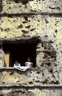 Life amongst the ruins. Two girls in an apartment building extensively damaged in the civil war.