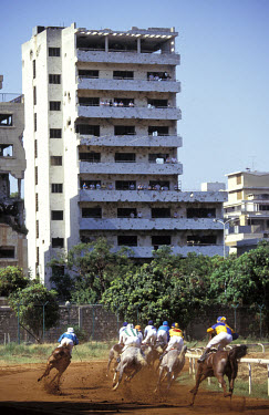 Horseracing at the Hippadrome. Spectators watch from an apartment building damaged in the civil war.