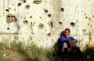 Horseracing in Beirut. British jockey Paul Buerke rests against a wall riddled with bullet holes, evidence of the civil war.