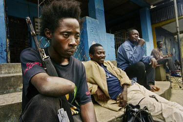 A veteran  fighter takes a  rest from the fighting here outside the fm headquarters of the National Bank of Liberia. The war in Liberia has been going on since 1989 and many fighters have been in it f...