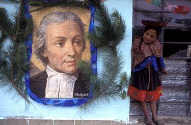 Young Hulloc Indian girl next to a portrait of her village's benefactor, the Frenchman De La Salle.