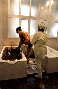 A state of the art hospital funded by the Azerbaijan state oil company which practises ancient treatments using oil to cure various ailments. Here, a patient lies in a bathtub filled with petrol for t...