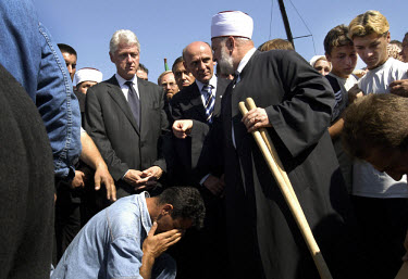 Former US President Bill Clinton, with Suleyman Tihic (middle), member of the Bosnian Presidency, and Mustafa Ceric (right), Bosnia's chief Immam, help to bury the remains of men from the Delic family...