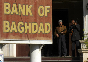 Armed guards on patrol in front of the Bank of Baghdad. Banks in Iraq are providing basic services again but a modern banking system has yet to be established.