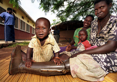 Mother and children at a rehabilitation centre in Gulu hospital where doctors have made her an artificial limb. Her leg was amputated after she stepped on a landmine.