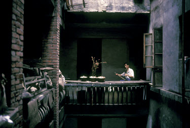 A man practises playing a lute in an old courtyard home. Much of old Shanghai is being bulldozed to make way for new developments.