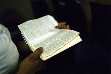 Victoria, a Nigerian sex worker, reading the Bible in Church. Thousands of Nigerian women are trafficked into Western Europe every year. They are forced to work in the sex industry to pay back debts o...