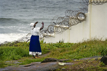 A woman, one of several hundred thousand displaced people living in central Monrovia, pleads for intervention outside the wall of the fortified US compound, Mamba Point.~The ongoing conflict in Liberi...