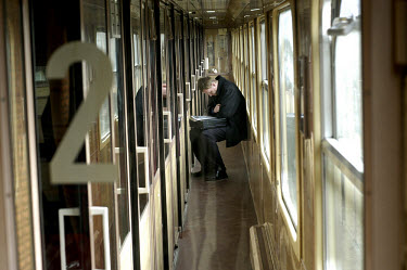 Passenger reading a newspaper on a train from Radom to Warsaw.