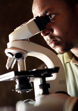 Doctor Mwanza, member of the mobile Sleeping Sickness screening team, examines a blood sample under a microscope looking for evidence of the parasites that cause the disease. Sleeping sickness is a da...