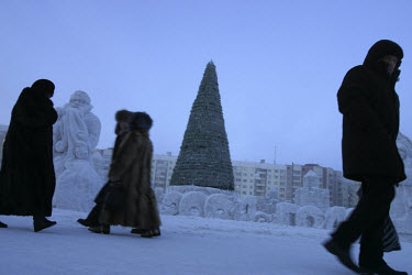 People dressed head to toe in fur pass a Christmas tree in the main square, still standing to greet the Orthodox New Year. Residents of this resource-rich city above the Arctic Circle in Siberia battl...