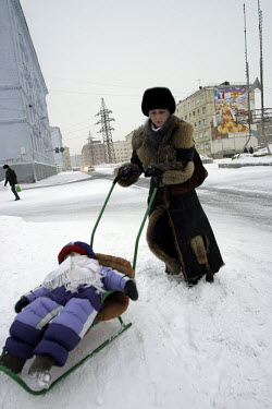 A woman pushes her baby on a sled through the snowy streets in temperatures of minus 30 degrees celsius. Residents of this resource-rich city above the Arctic Circle in Siberia battle long polar night...
