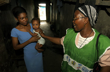 A health worker says goodbye to a child and its mother after checking to see that the child had been vaccinated against polio. Health officials are trying to vaccinate as many children as possible aft...