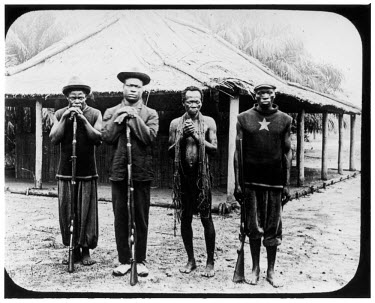 Three head sentries of the ABIR (Anglo-Belgian India Rubber company) with a prisoner.   The Belgian Congo under King Leopold II employed mass forced labour of the indigenous population to extract rubb...
