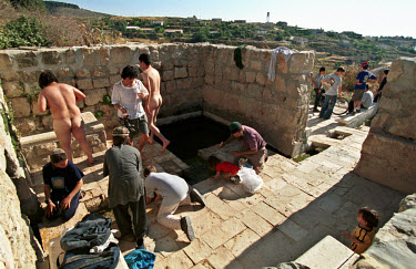 Settlers in an old fountain on the outskirts of  the Jewish settlement of Bat A'in.  The settlement is inhabited by ultra-orthodox Jews, maintaining an environmental-friendly way of life, combined wit...
