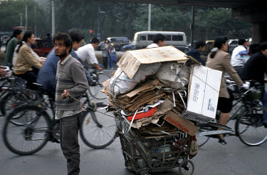 Migrant with cardboard collected to sell for recycling.