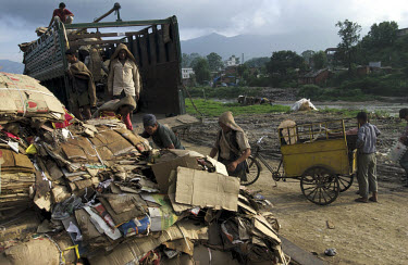 By the riverbanks of the Bagmati river (near its confluence with the Balkhu), cardboard waste is collected to be weighed, paid for, loaded onto trucks and transported to recycling plants.
