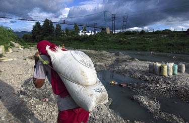 Silt being dredged from the bed of the Manahara river, a tributary of the Bagmati. Bags of the dried and sifted silt are then sold to the cement industry for about 30 rupees (40 cents) a bag.