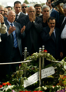Palestinian Prime Minister Ahmed Qurei (aka Abu Ala) (left), prays with other members of the Palestinian Authority next to the grave of Yasser Arafat, shortly after his burial.