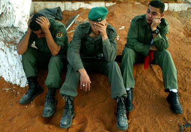 Emotional Palestinian soldiers next to the grave of Yasser Arafat, shortly after his burial.