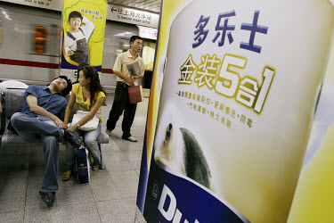 Couple in the subway surrounded by Dulux paint advertisements.