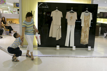 A spoilt child hangs on to his mother in a Shanghai department store.