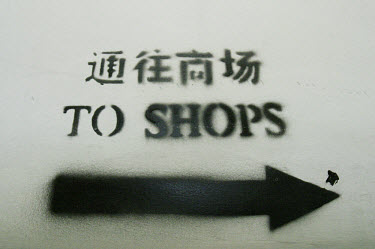Sign saying "To Shops" in Chinese and English.