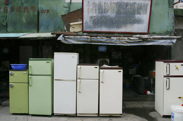 Second hand fridges for sale in an outdoor market.