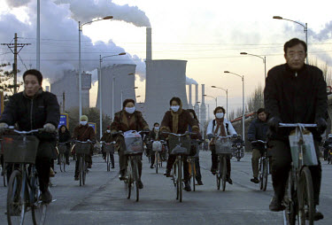 Factory workers cycle home after work at the state-owned Baotou iron and steel works.