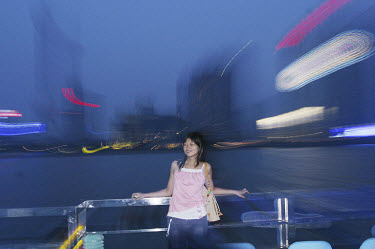 Girl posing for photograph by the Huangpu river in the centre of the city.