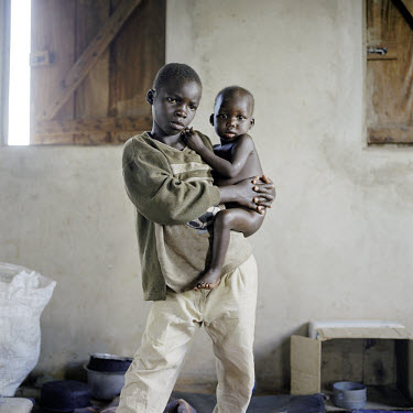 Wiliam Otoa (10) holding his 2 year old brother Innocent in the feeding centre run by MSF (Medecins Sans Frontieres). They are orphans. Wiliam is a former LRA (Lord's Resistance Army) abductee. He was...