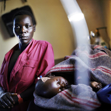 Flow Awid sits next to her severely ill daughter Jullet who died later that night in this feeding centre run by Medecins Sans Frontieres (MSF).For 18 years the Lord's Resistance Army (LRA) rebels have...