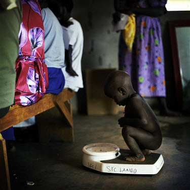 A young boy crouching on a set of scales waiting to be weighed in an MSF (Medecins sans Frontieres) feeding centre for IDPs (internally displaced people).For 18 years the Lord's Resistance Army (LRA)...