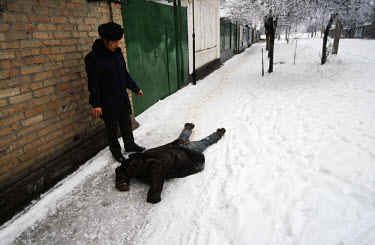 A man trying to drag another to safety after a mortar attack in central Grozny.
