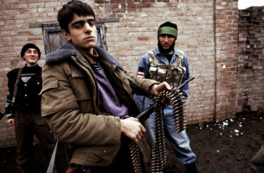 Young volunteers to the Chechen military forces pose with weapons in their home village.