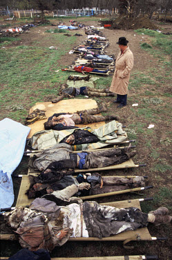 A man looks for his son among bodies laid out in a field, collected from Grozny�s streets after the Russian military secured the town in February 1996.