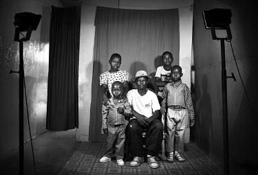 Five siblings pose for a family photo in a studio. They are AIDS orphans. Deaths from AIDS have increased the number of single-parent and child-headed households.