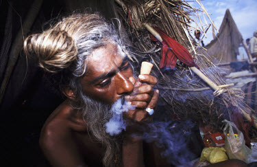 A sadhu smoking marijuana. Sadhus are ascetics whose feats of self mortification are designed to cleanse the mind and demonstrate spiritual control over the physical being. They are legally permitted...