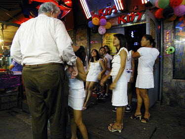 A customer is lured into a girlie bar in the Patpong district, a mecca for sex tourists.