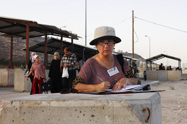 Naomi Lalo, 55, from the Israeli city of Kefar Saba, during her 'Machsom Watch' shift at the West Bank military checkpoint of Hawarrah. 'Machsom Watch' is a women's NGO whose aim is to observe the con...