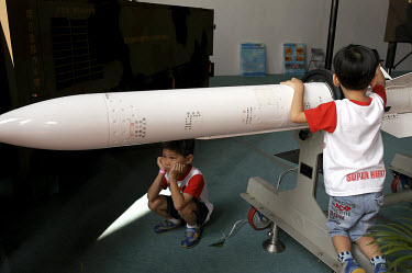 Children play with a surface to air missile at an air show at a military base near Taipei. Taiwan faces the threat of around 500 missiles pointed towards it across the Taiwan Strait from mainland Chin...